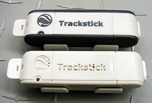 Two Trackstick GPS loggers, one black and one white, with over-molded grips